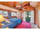 Bedroom with vaulted wood ceilings with fan and sliding glass doors to a private deck at 681 Olive St, Englewood, FL 34223