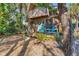 Inviting front porch with bright blue chairs, complementing the rustic exterior and lush landscaping at 681 Olive St, Englewood, FL 34223