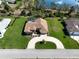 Aerial view of a well-maintained home with a large front yard, driveway, and in-ground pool at 70 Sportsman Rd, Rotonda West, FL 33947