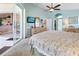 Bright main bedroom featuring sliding glass doors, ceiling fan, and a wooden dresser with a wall-mounted TV at 70 Sportsman Rd, Rotonda West, FL 33947