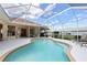 Enjoy this enclosed pool area with bright skies above and sliding glass door access to the home at 70 Sportsman Rd, Rotonda West, FL 33947