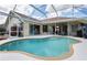 Bright enclosed pool area with steps leading into the pool and sliding glass door access to the home at 70 Sportsman Rd, Rotonda West, FL 33947