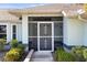 Welcoming front porch with decorative screen door and mature landscaping at 803 Diane Cir, Englewood, FL 34223