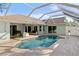 Enclosed pool area with in-ground pool and stone tile surrounding the pool at 803 Diane Cir, Englewood, FL 34223