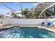 Enclosed in-ground pool featuring blue tile, ladder and outdoor seating at 803 Diane Cir, Englewood, FL 34223