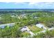 Gorgeous aerial view of the home, pool, large lawn, and Florida woodlands surrounding the neighborhood at 8205 Chico St, Port Charlotte, FL 33981