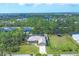 Aerial view of a well-maintained home with pool, storage shed, and tree-lined surroundings at 8205 Chico St, Port Charlotte, FL 33981