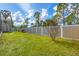 Wide backyard featuring well maintained lawn, white fence, trees, and storage shed at 8205 Chico St, Port Charlotte, FL 33981