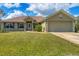 Attractive home featuring a manicured front lawn, complementary shutters, and an attached two-car garage at 8205 Chico St, Port Charlotte, FL 33981