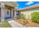 Inviting front porch with a decorative door, stylish lighting, and a landscaped garden area at 8205 Chico St, Port Charlotte, FL 33981