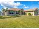 Charming home with a well-maintained lawn, neutral stucco, and a welcoming front entrance with decorative columns at 8205 Chico St, Port Charlotte, FL 33981