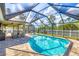 View of a sparkling pool with a screened enclosure and outdoor dining area at 8205 Chico St, Port Charlotte, FL 33981