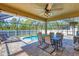 Inviting covered patio with dining set and chairs, overlooking the refreshing swimming pool at 8205 Chico St, Port Charlotte, FL 33981