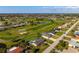 Beautiful aerial view of home and yard with pool on golf course in a sunny neighborhood at 84 Caddy Rd, Rotonda West, FL 33947