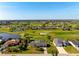 Aerial view of a home with a pool, set amidst a golf course and lush landscaping at 84 Caddy Rd, Rotonda West, FL 33947