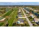 Aerial view of a home with a pool on a golf course, located on a canal in a neighborhood at 84 Caddy Rd, Rotonda West, FL 33947