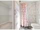 Bathroom with a marble-look tiled shower, floral curtain, and a view to a closet with wire shelving at 84 Caddy Rd, Rotonda West, FL 33947