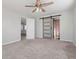 Bedroom featuring ceiling fan and carpet floors with barn door access to an en suite bathroom at 84 Caddy Rd, Rotonda West, FL 33947