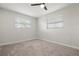 Empty bedroom featuring neutral carpet, two windows with blinds and a ceiling fan at 84 Caddy Rd, Rotonda West, FL 33947