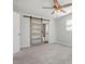 Bedroom with carpet flooring, ceiling fan and barn door access to an en suite bathroom at 84 Caddy Rd, Rotonda West, FL 33947