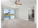 Sun-filled bedroom with carpet flooring, ceiling fan, and view to the pool at 84 Caddy Rd, Rotonda West, FL 33947