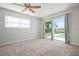 Light-filled bedroom with carpet flooring, ceiling fan, and a sliding glass door to the pool at 84 Caddy Rd, Rotonda West, FL 33947