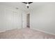 Bedroom with neutral carpet, closet with sliding doors, ceiling fan, and an adjacent doorway at 84 Caddy Rd, Rotonda West, FL 33947