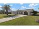 Single-story home with attached garage, well-maintained lawn and mature landscaping at 84 Caddy Rd, Rotonda West, FL 33947