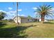 Charming single-story home featuring a well-manicured lawn and mature palm trees at 84 Caddy Rd, Rotonda West, FL 33947