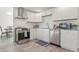 Bright kitchen with stainless steel appliances, tile backsplash and wood grain tile flooring at 84 Caddy Rd, Rotonda West, FL 33947