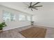 Spacious, naturally lit living space with wood-look flooring and modern ceiling fan at 84 Caddy Rd, Rotonda West, FL 33947