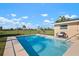 Backyard swimming pool with inviting blue water and a seating area, ideal for outdoor enjoyment at 84 Caddy Rd, Rotonda West, FL 33947