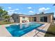 An outdoor swimming pool, perfect for hot days, alongside a well-maintained backyard and patio at 84 Caddy Rd, Rotonda West, FL 33947