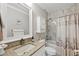 Bathroom featuring marble accent wall, vanity with granite countertop, tub and shower combo with shower curtain at 8403 Placida Rd # 401, Placida, FL 33946