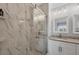 This bathroom features white marbled tile in the shower and around the vanity with granite counter, creating an oasis at 8403 Placida Rd # 401, Placida, FL 33946