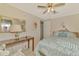 Relaxing bedroom features a ceiling fan, bedside table, and patterned bedding at 8431 Nighthawk Dr, Englewood, FL 34224