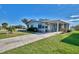 Well-maintained single story home with a covered carport and well maintained landscaping, green grass and blue skies at 8431 Nighthawk Dr, Englewood, FL 34224