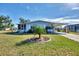 Charming single-story home with well-maintained landscaping, green grass and blue skies at 8431 Nighthawk Dr, Englewood, FL 34224