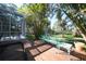 A bench sits next to the house, and a backyard with lush landscaping and mature trees in the background at 955 Morrison Ave, Englewood, FL 34223