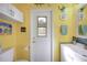 Bright, fun bathroom with yellow walls, frog decor, and unique mosaic tile accents at 955 Morrison Ave, Englewood, FL 34223