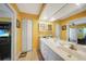 Bright bathroom with a double vanity, white cabinets, and a large mirror at 955 Morrison Ave, Englewood, FL 34223