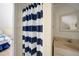 Bathroom with a blue and white striped shower curtain separating the room from the bedroom at 955 Morrison Ave, Englewood, FL 34223