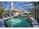 View of the screened-in pool and spa area featuring tile accents and a dolphin statue at 955 Morrison Ave, Englewood, FL 34223