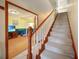 Carpeted staircase with white railing leads to the upper level of the home at 955 Morrison Ave, Englewood, FL 34223