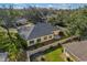 An aerial view of a yellow home with a grey roof surrounded by lush landscaping and a privacy wall at 10 Bermuda Cir # 57, Englewood, FL 34223