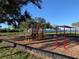 Brightly colored playground with swings and climbing equipment near the water, perfect for Gathering fun at 12116 Shellnut Ave, Port Charlotte, FL 33981