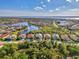 An aerial shot shows several homes near the lake surrounded by mature landscaping and lush greenery at 13241 Scrub Jay Ct, Port Charlotte, FL 33953