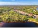 An aerial view of a lakeside home with mature landscaping, sunny skies and a large lake at 13241 Scrub Jay Ct, Port Charlotte, FL 33953