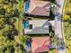 Aerial shot shows neighboring backyard pools and landscaping, next to street with mature trees at 13241 Scrub Jay Ct, Port Charlotte, FL 33953