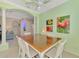 Dining area features a ceiling fan, white chairs, and open views of the living spaces at 13241 Scrub Jay Ct, Port Charlotte, FL 33953